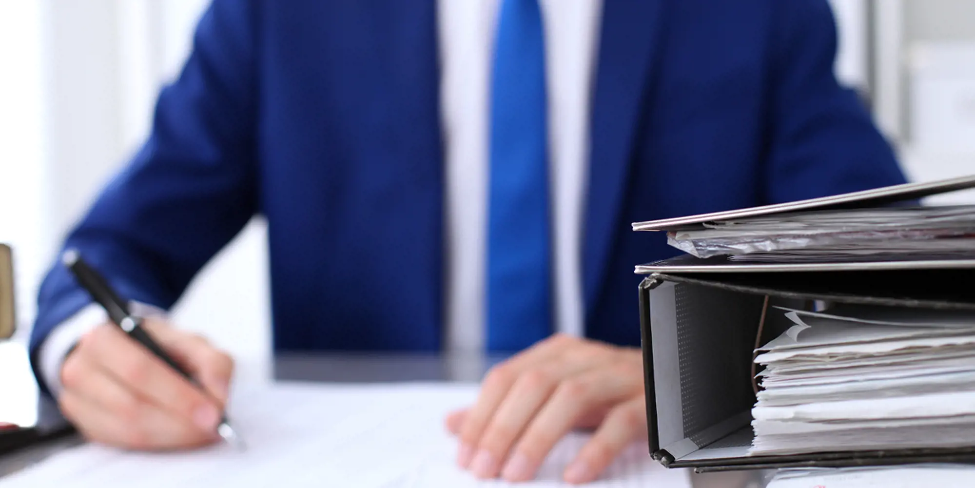 binders-with-papers-are-waiting-be-processed-with-businessman-back-blur-accounting-planning-budget-audit-insurance-business-concept-1