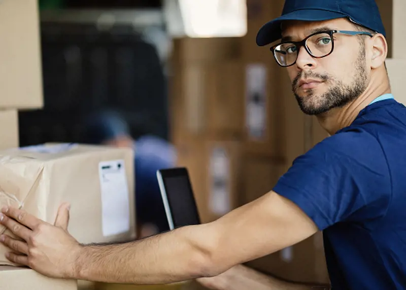 delivery-man-scanning-bar-code-package-with-touchpad-while-looking-camera-1