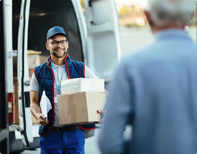 happy-deliverer-carrying-packages-while-making-home-delivery-his-customer