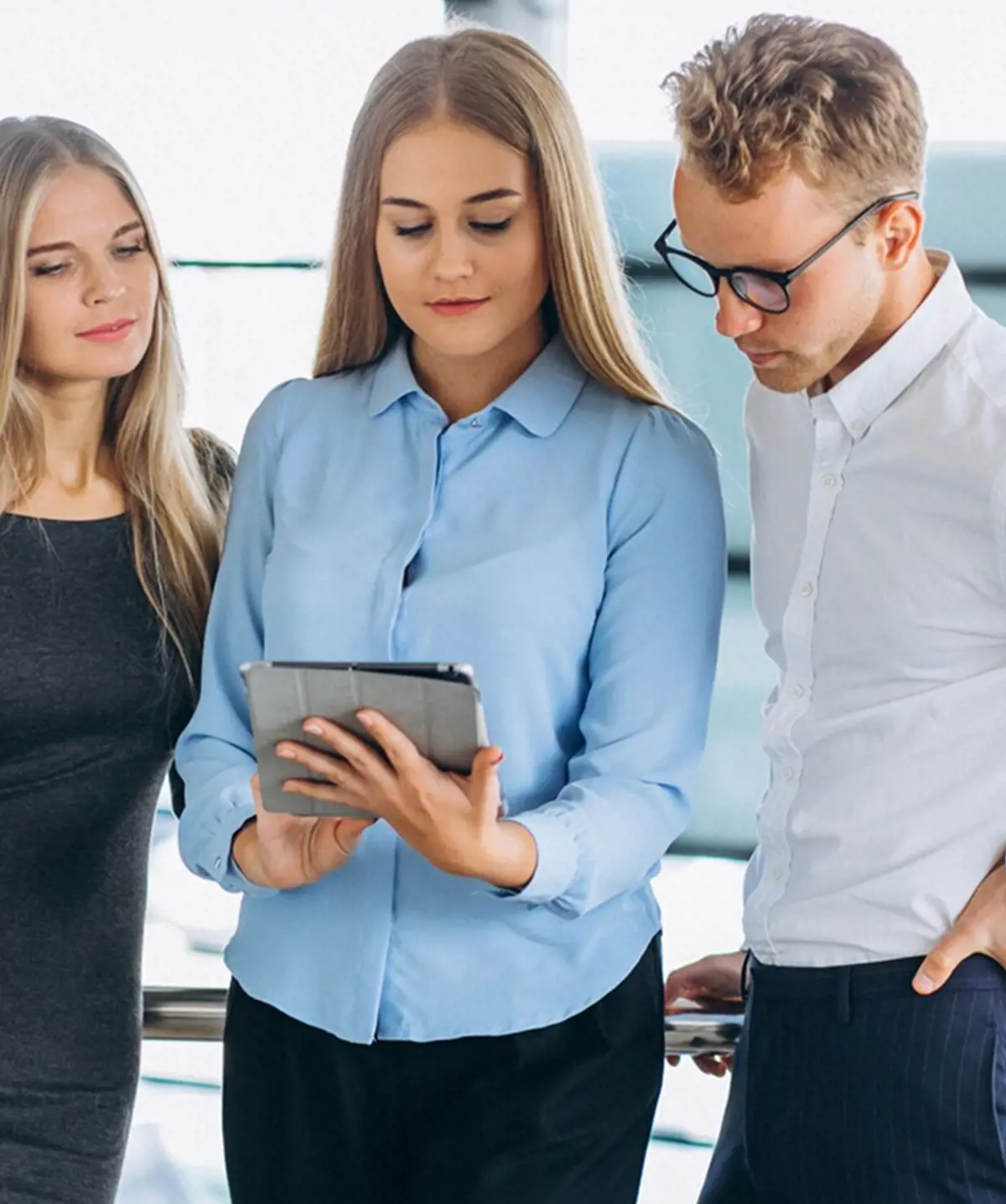 two-woman-and-one-man-looking-at-tablet